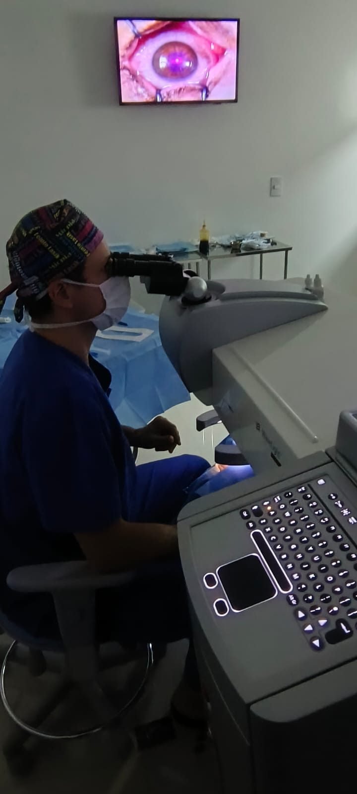 Dr. Jefferson Batista no microscópio do novo laser, com a imagem do olho no monitor